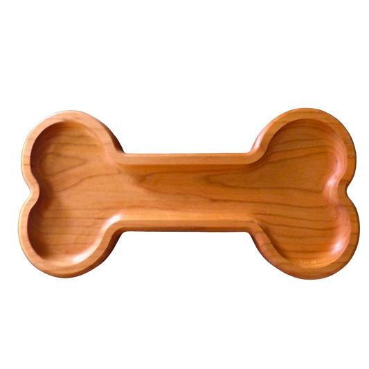 A bone-shaped wooden tray with a smooth, polished finish and visible wood grain, shown on a checkered transparency background.
