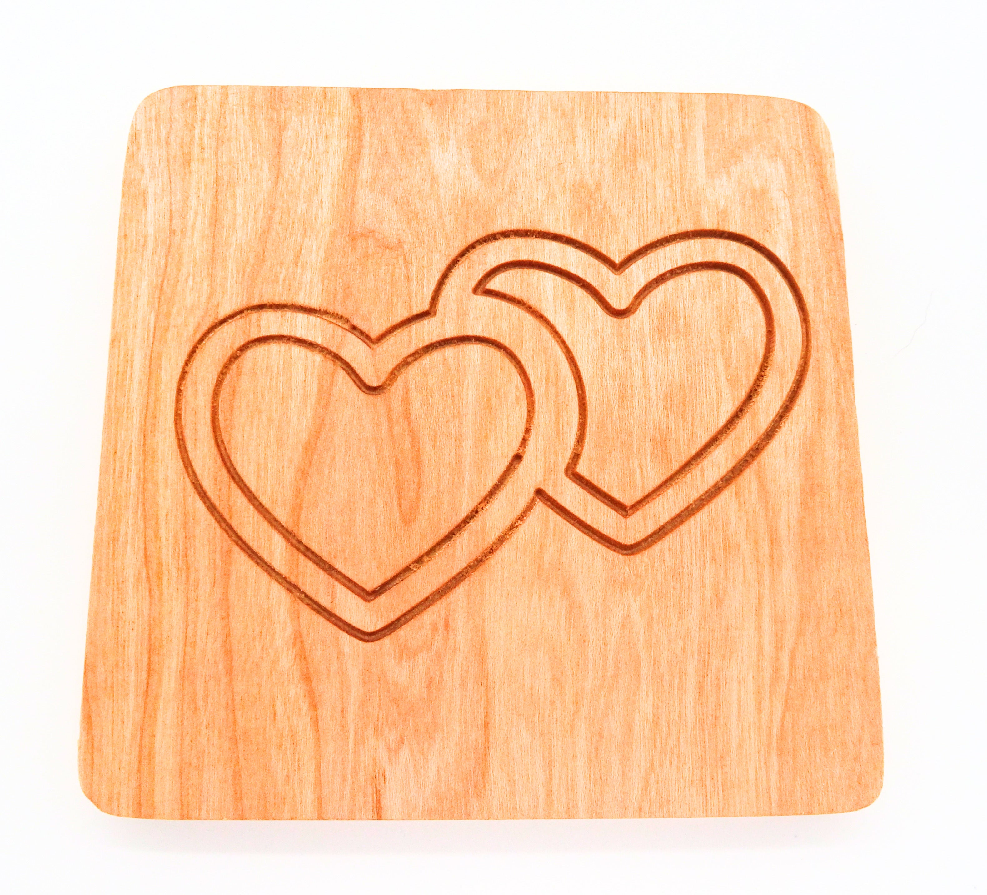 square cherry wooden coaster with two interlocking hearts engraved