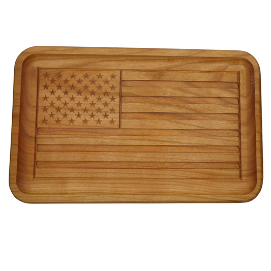 A rectangular wooden serving tray with rounded corners, featuring an engraved American flag design on the top surface. The tray has a warm medium-brown wood grain and a raised rim, shown against a plain white background.